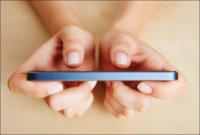 Dos pulgares arriba manos femeninas escribiendo en un teléfono inteligente