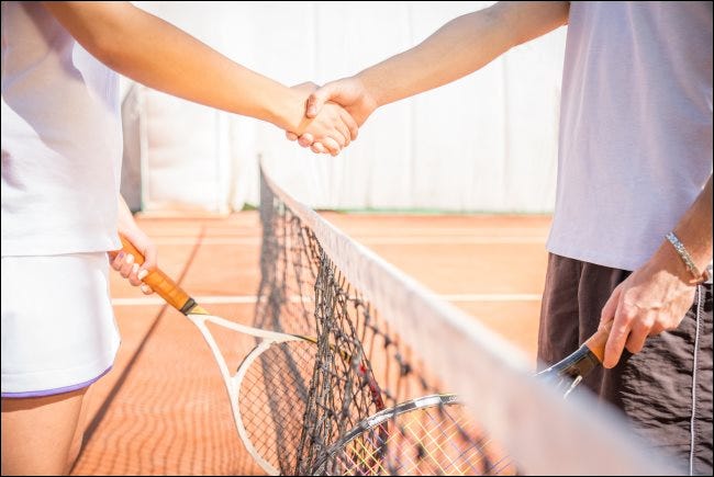 Dos jugadores un apretón de manos en una cancha de tenis