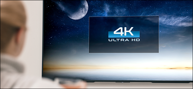 Persona que mira un televisor de pantalla grande de 4K.