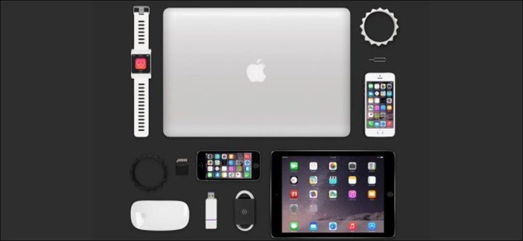 Una MacBook, iPad, Apple Watch, varios iPhones y otros accesorios de Apple en una mesa.