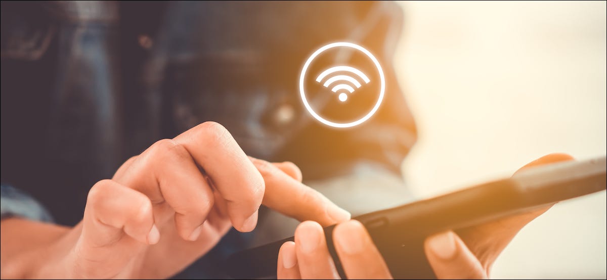 Símbolo de Wi-Fi flotando sobre un teléfono inteligente en la mano de alguien