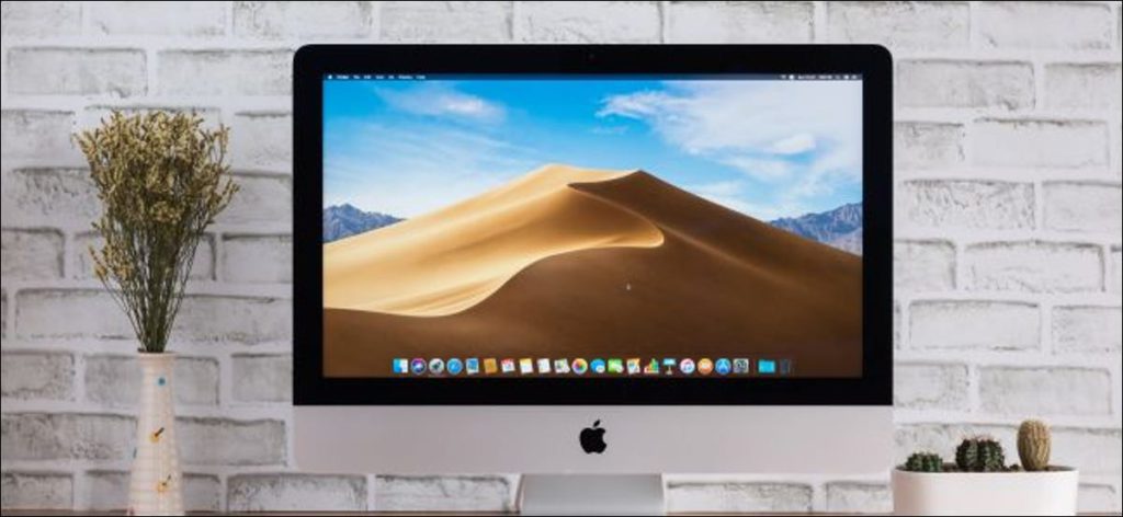 Un iMac de Apple con una imagen de fondo de escritorio macOS Mojave.