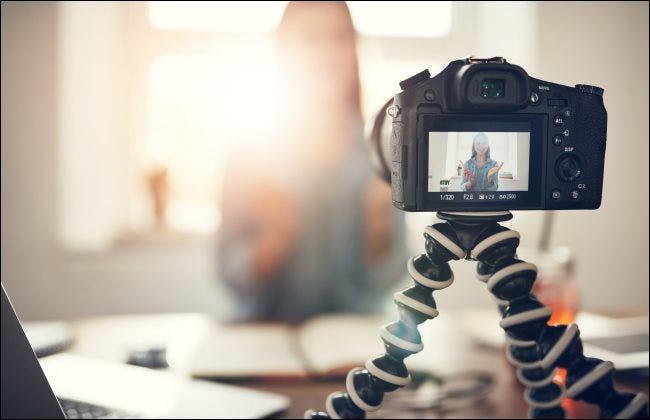 Una cámara sobre un trípode filma a una mujer hablando.