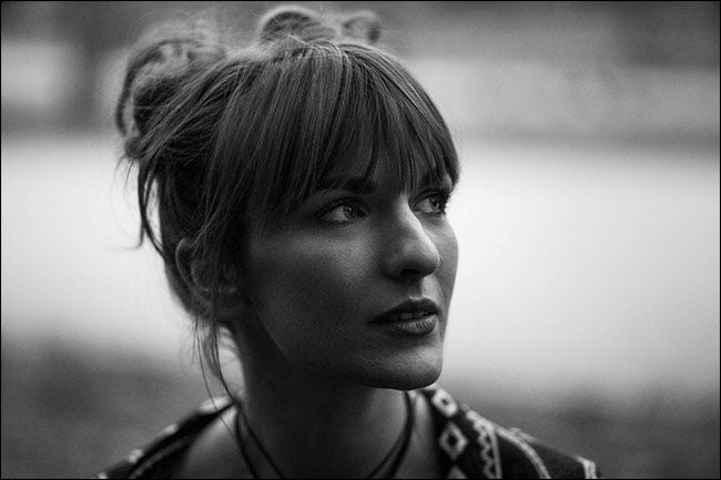 Un retrato en blanco y negro de una mujer con un fondo completamente borroso. 