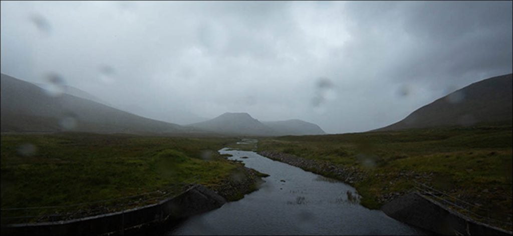 Una montaña y un arroyo en un día nublado y húmedo.