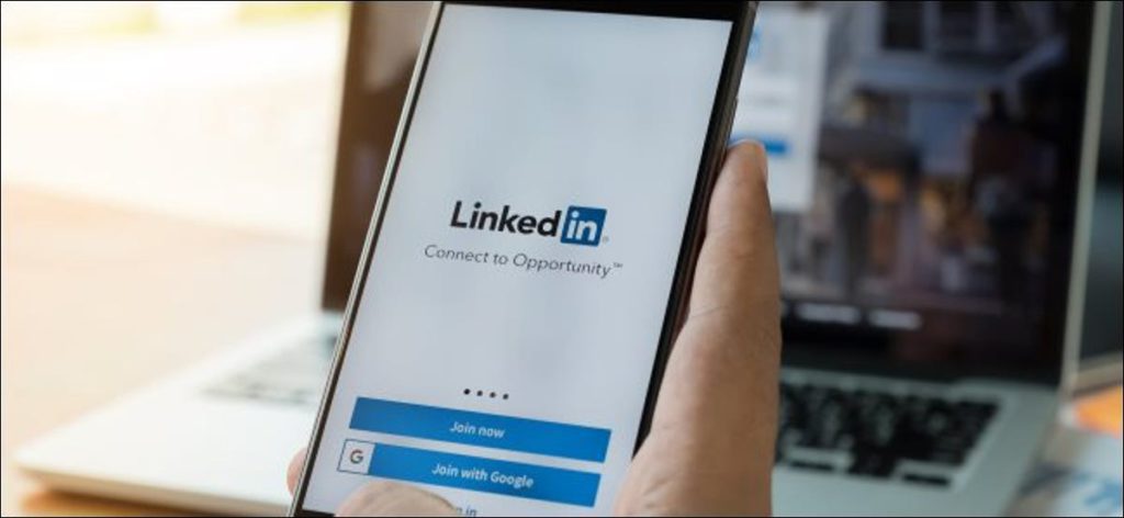 La aplicación de LinkedIn en un teléfono inteligente y el sitio web en una computadora portátil.