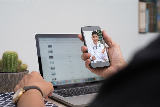 Un hombre se comunica con un médico a través de un chat de video en un teléfono inteligente.