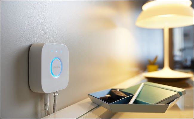 Concentrador Philips Hue junto a una lámpara en un tocador.