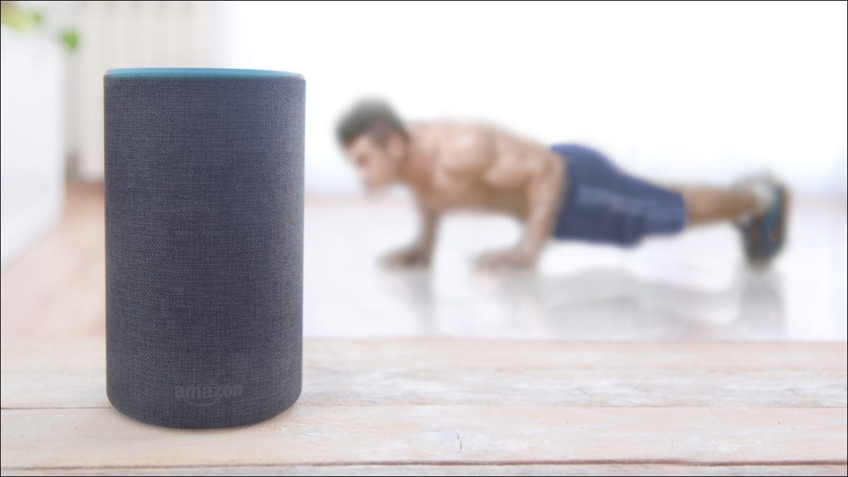 Un hombre hace flexiones detrás de un altavoz Amazon Echo Plus.