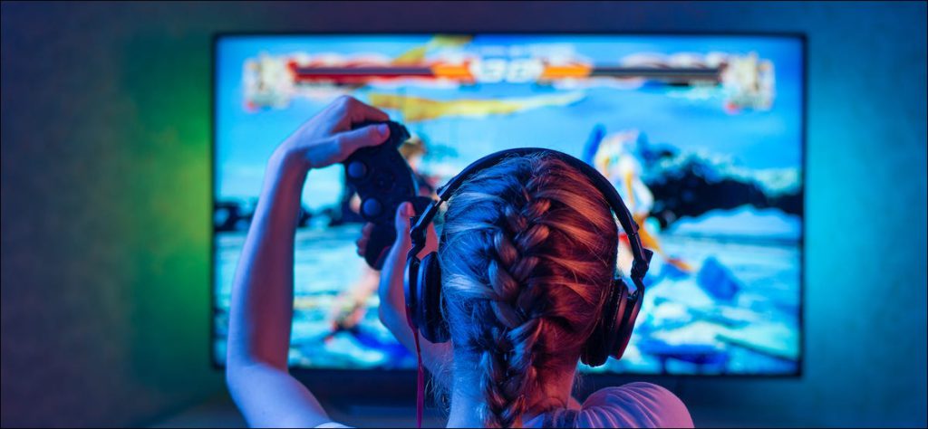 Persona jugando videojuegos en un televisor con luz de fondo