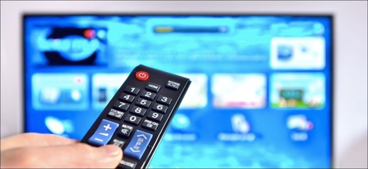 Smart TV y control remoto presionando manualmente