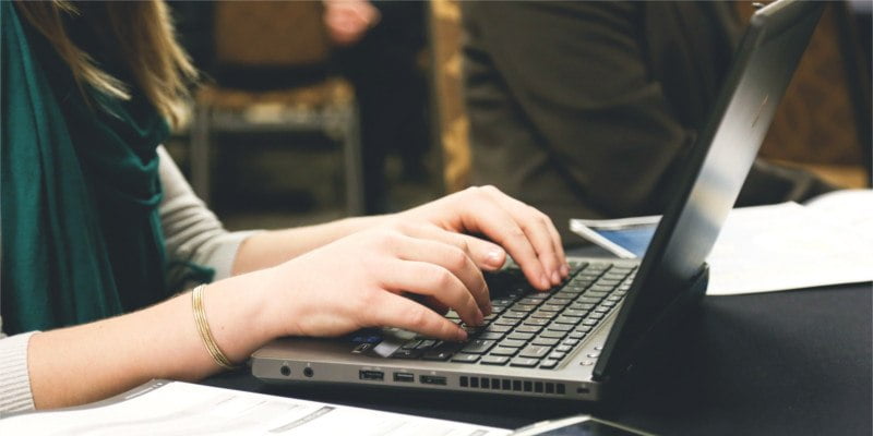 Person typing at laptop computer