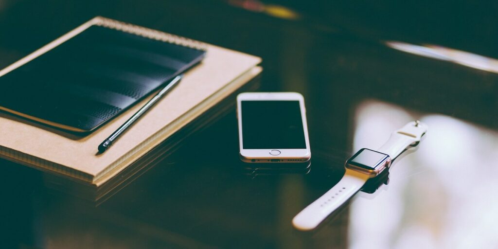 A desk showing an iPhone and Apple Watch.