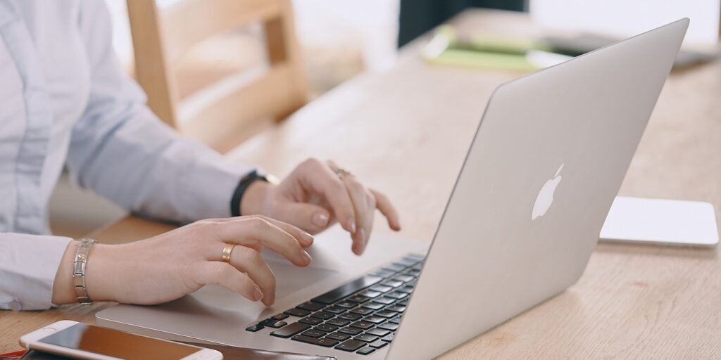 Photo of a woman typing on her Macbook