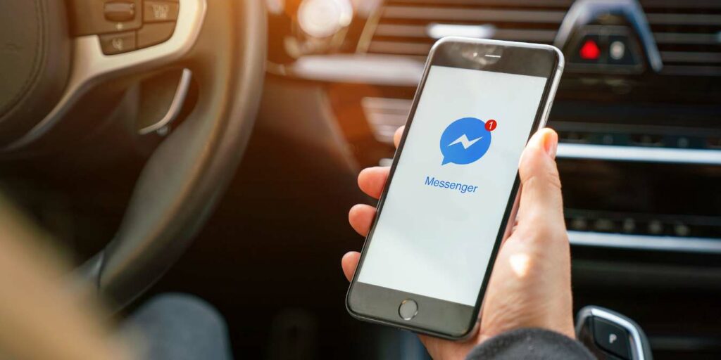 Aachen, Germany August 2019: Woman Holding A Apple Iphone Opening Facebook Messenger App In A Car. Facebook Is The World Largest Social Media Plattform