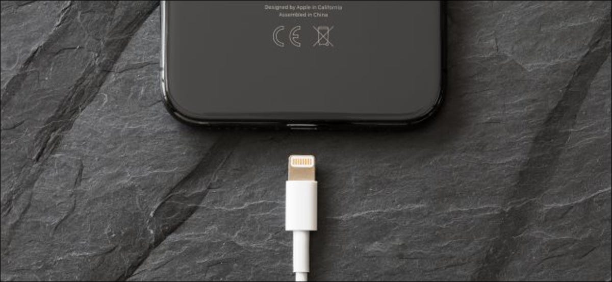 Un cable Lightning a punto de conectarse a un iPhone X.